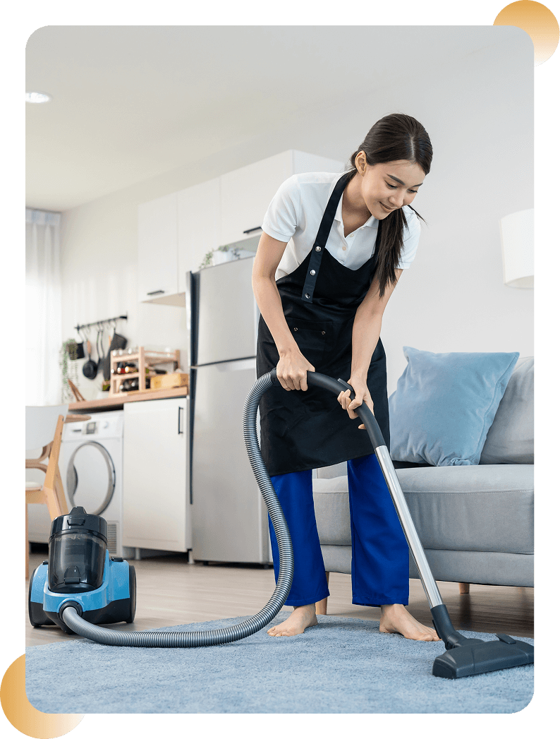 Woman vacuuming living room carpet, wearing apron.